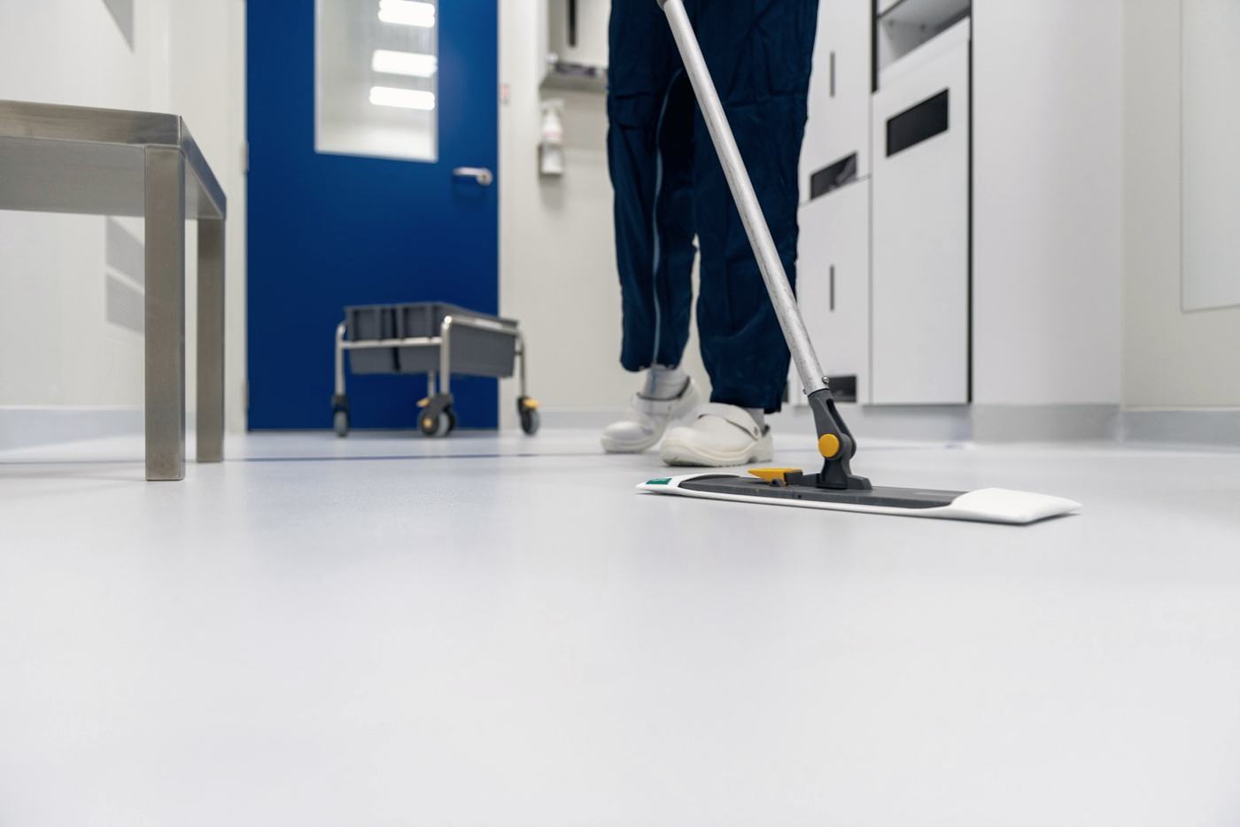 Cleaner mopping the floor of a clinical corridor